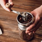 ミルでコーヒー豆を挽く人